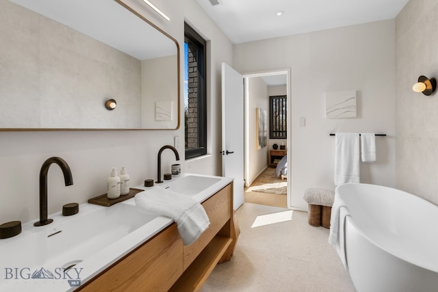ensuite bathroom with a freestanding bath and vanity