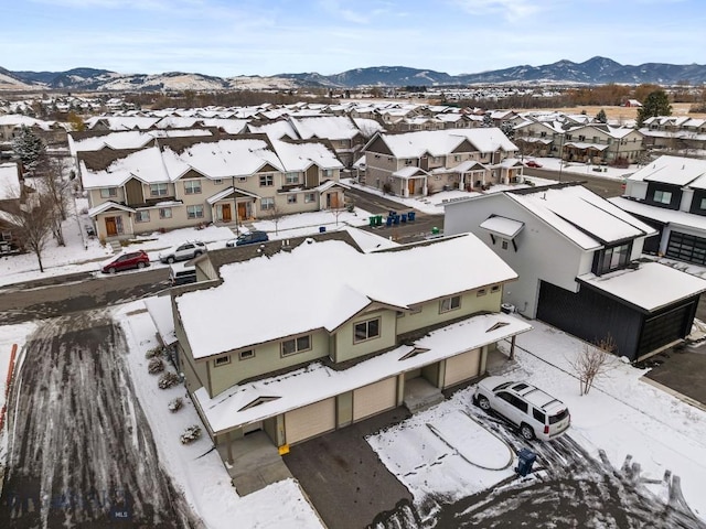 snowy aerial view with a residential view and a mountain view