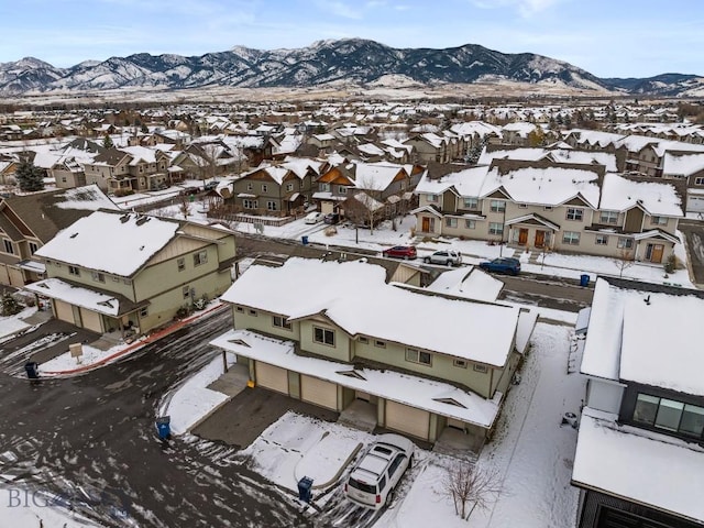 snowy aerial view featuring a residential view and a mountain view