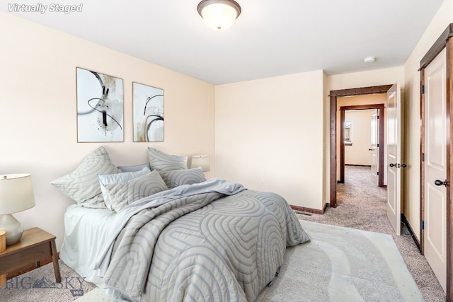bedroom featuring light carpet and baseboards