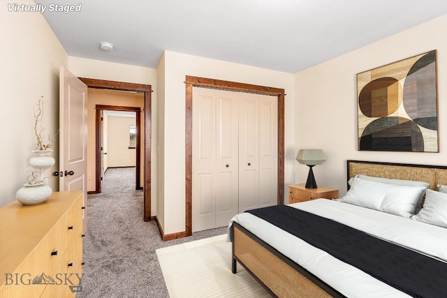 bedroom featuring light colored carpet, a closet, and baseboards