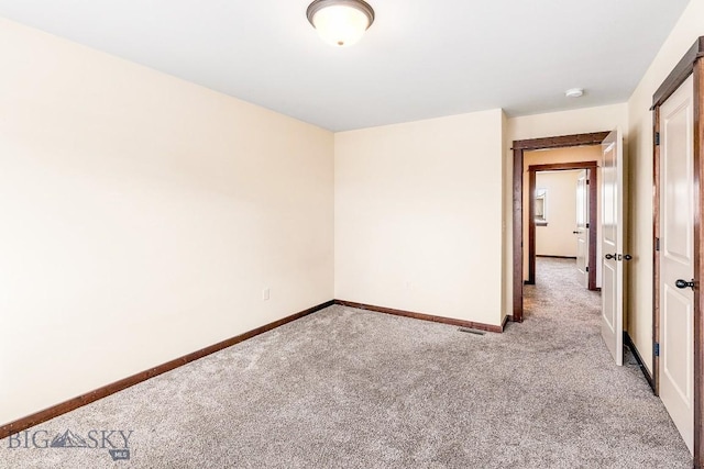 unfurnished room with light carpet and baseboards