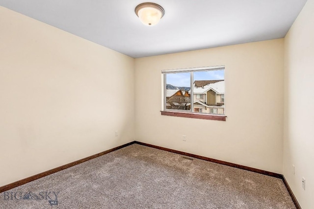 carpeted spare room with baseboards