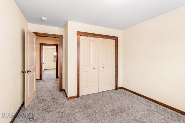 unfurnished bedroom with light carpet, baseboards, and a closet