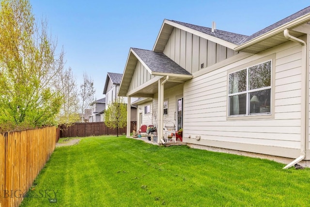 182 Snowy Owl Trl, Bozeman, MT 59718 - back of property with board and batten siding, a shingled roof, and a patio