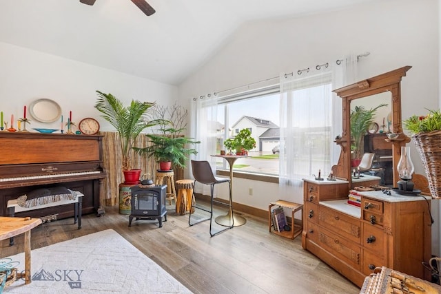 182 Snowy Owl Trl, Bozeman, MT 59718 - living area with vaulted ceiling, a wood stove, ceiling fan, light wood finished floors, and baseboards