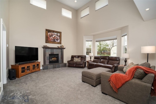 508 Coral Dr, Belgrade, MT 59714 - living room featuring carpet flooring, a towering ceiling, a tile fireplace, and recessed lighting