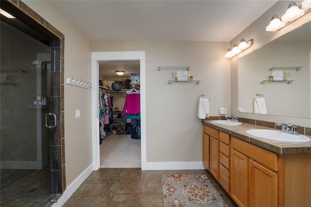 508 Coral Dr, Belgrade, MT 59714 - bathroom featuring double vanity, a spacious closet, baseboards, and a stall shower