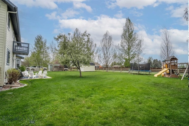 508 Coral Dr, Belgrade, MT 59714 - view of yard featuring a trampoline, a playground, a balcony, and a patio area