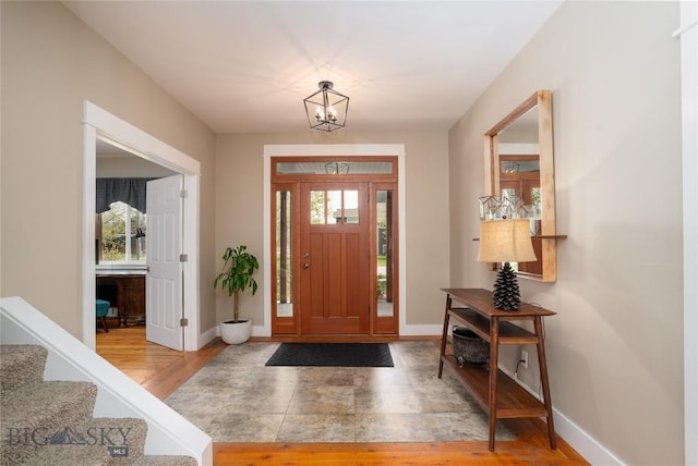 508 Coral Dr, Belgrade, MT 59714 - foyer featuring wood finished floors, baseboards, a chandelier, and stairs