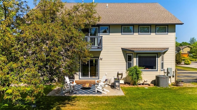 508 Coral Dr, Belgrade, MT 59714 - rear view of house with central AC unit, a balcony, a patio area, a yard, and roof with shingles