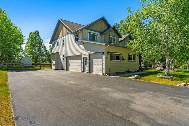 508 Coral Dr, Belgrade, MT 59714 - view of property exterior with board and batten siding, driveway, and a garage