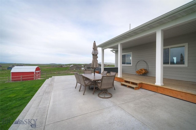 36 Sante Fe, Three Forks, MT 59752 - view of patio featuring an outdoor structure, outdoor dining space, a wooden deck, and a barn