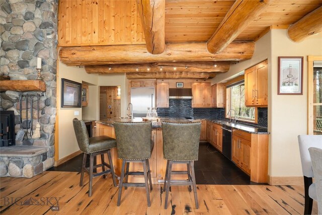 9704 River Rd, Bozeman, MT 59718 - kitchen with dishwashing machine, beamed ceiling, under cabinet range hood, backsplash, and dark wood finished floors
