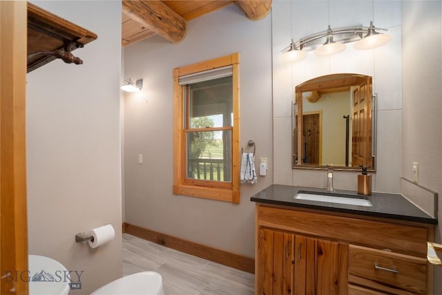 9704 River Rd, Bozeman, MT 59718 - half bath with toilet, beamed ceiling, vanity, and baseboards