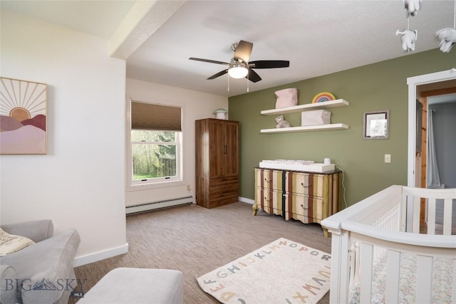 9704 River Rd, Bozeman, MT 59718 - carpeted bedroom featuring a baseboard heating unit, baseboards, a nursery area, and a ceiling fan