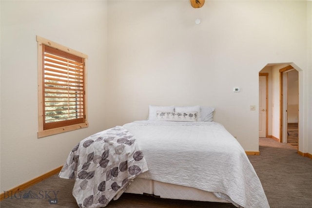 9704 River Rd, Bozeman, MT 59718 - bedroom featuring baseboards, arched walkways, and carpet floors