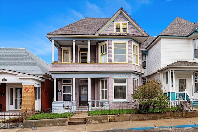 822 W Park St, Butte, MT 59701 - view of front of house featuring a porch, a fenced front yard, brick siding, and a balcony