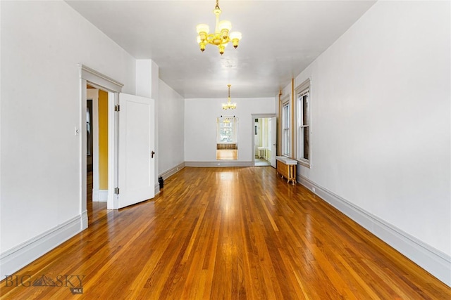 822 W Park St, Butte, MT 59701 - spare room featuring a chandelier, wood finished floors, and baseboards