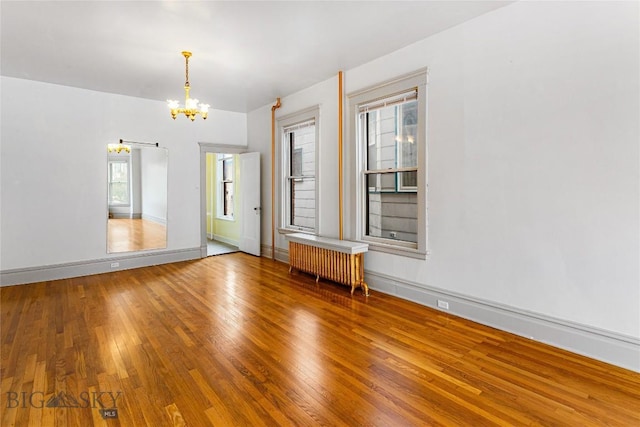 822 W Park St, Butte, MT 59701 - unfurnished room with radiator heating unit, a chandelier, hardwood / wood-style flooring, and baseboards