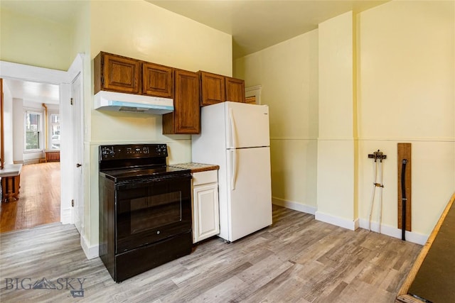 822 W Park St, Butte, MT 59701 - kitchen featuring under cabinet range hood, black range with electric cooktop, freestanding refrigerator, light wood finished floors, and light countertops