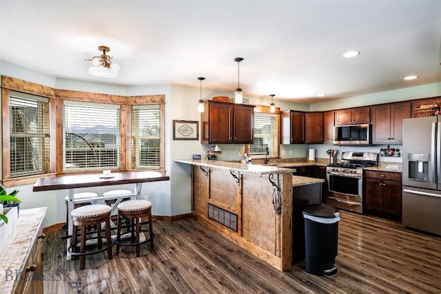 1602 Ingomar Blvd, Belgrade, MT 59714 - kitchen featuring stainless steel appliances, baseboards, a peninsula, dark wood finished floors, and recessed lighting