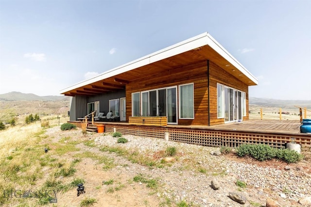 rear view of property featuring a deck with mountain view
