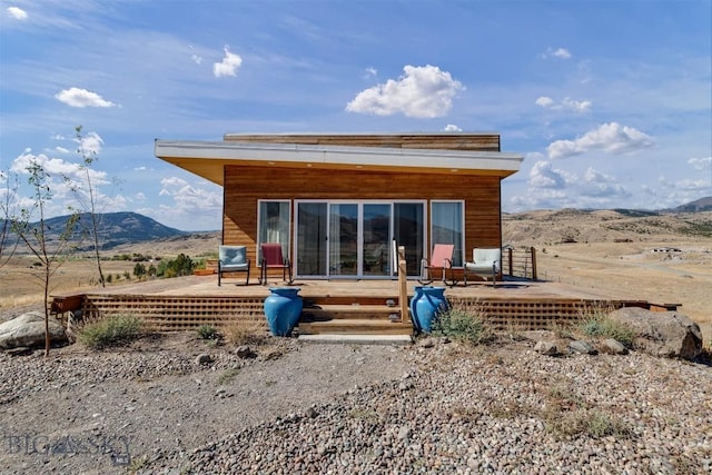 back of property with a deck with mountain view