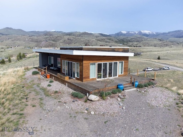 back of property featuring a deck with mountain view