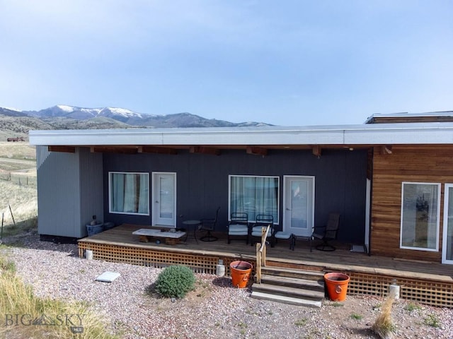 back of property with a deck with mountain view