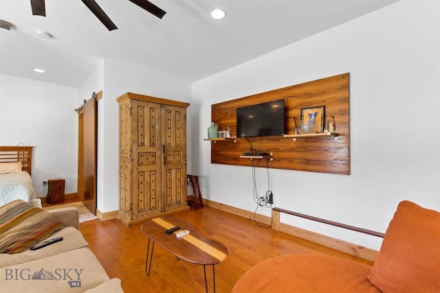 living area with a ceiling fan, wood finished floors, baseboards, and recessed lighting