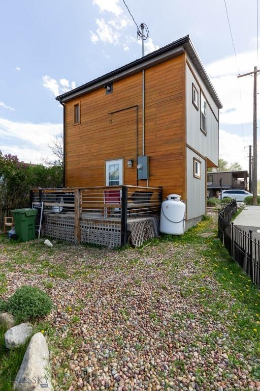 rear view of property featuring fence and a deck
