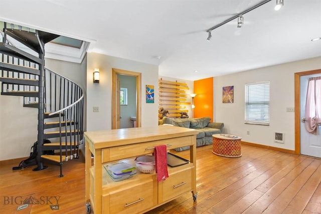 kitchen with hardwood / wood-style flooring, baseboards, and track lighting