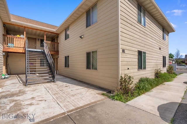 view of side of property featuring stairway and a patio