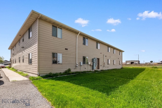 back of property featuring a lawn
