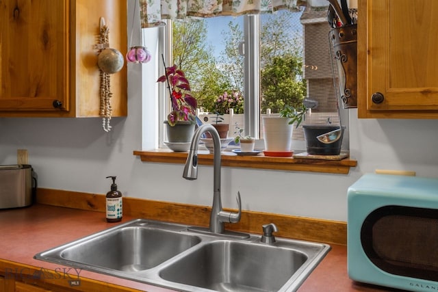 kitchen view of a sink and brown cabinetry