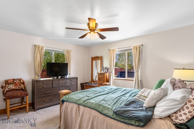 bedroom with light carpet, multiple windows, and a ceiling fan