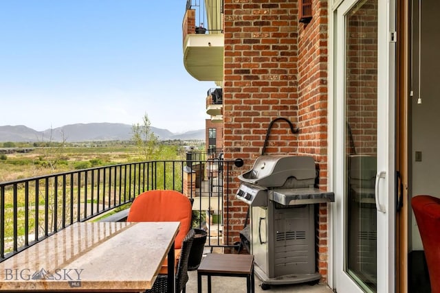 balcony with a mountain view, a grill, and outdoor dining area