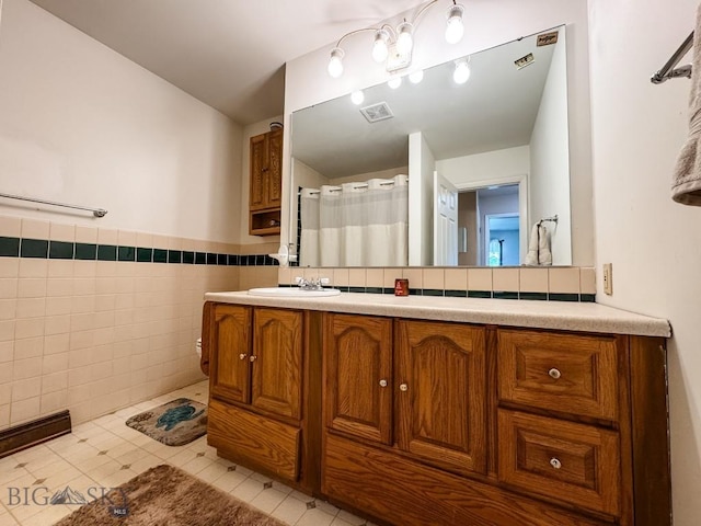 607 Meadowlark Ln, Livingston, MT 59047 - full bathroom with tile walls, vanity, wainscoting, and a shower with shower curtain