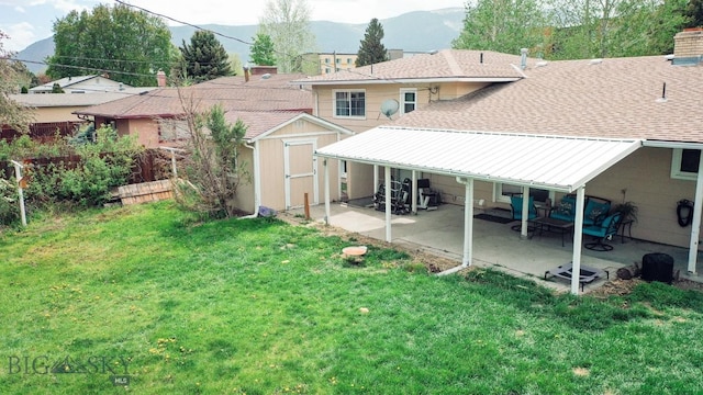 607 Meadowlark Ln, Livingston, MT 59047 - back of property featuring a patio area, a shed, a mountain view, an outdoor structure, and roof with shingles