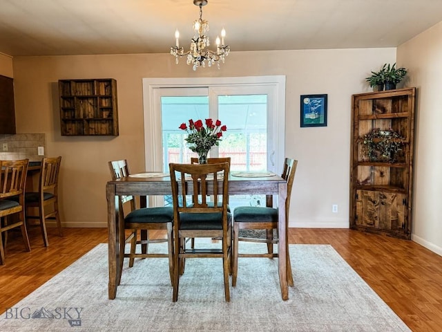607 Meadowlark Ln, Livingston, MT 59047 - dining area with wood finished floors, a chandelier, and baseboards