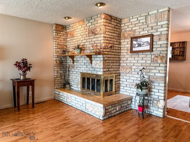 607 Meadowlark Ln, Livingston, MT 59047 - living room featuring a textured ceiling, wood finished floors, a fireplace, and baseboards