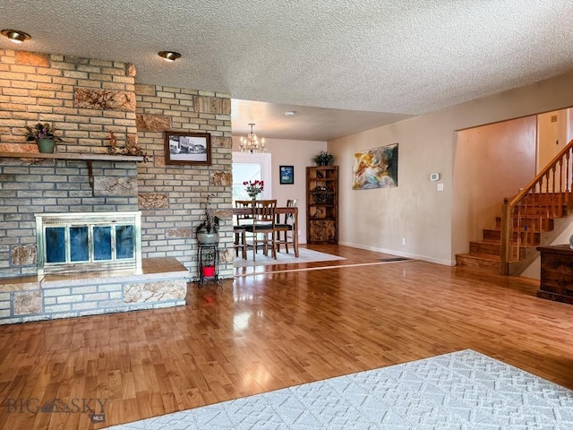 607 Meadowlark Ln, Livingston, MT 59047 - living room with a textured ceiling, a chandelier, wood finished floors, stairs, and baseboards