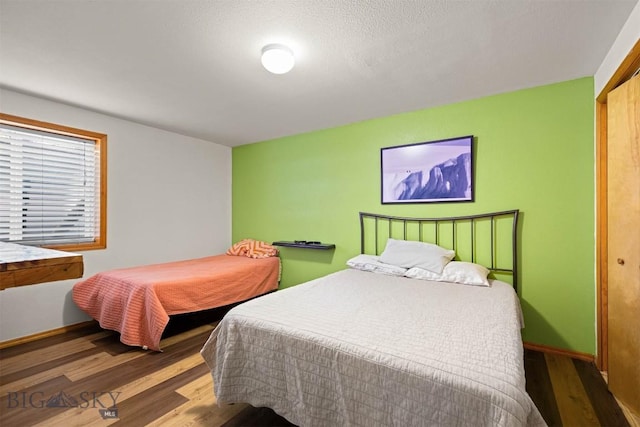 bedroom featuring wood finished floors and baseboards