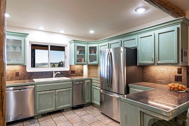 952 N Meadow Creek Rd, Mcallister, MT 59740 - kitchen with appliances with stainless steel finishes, green cabinetry, backsplash, glass insert cabinets, and recessed lighting