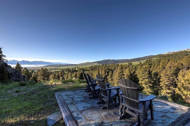view of patio / terrace featuring a mountain view and a view of trees