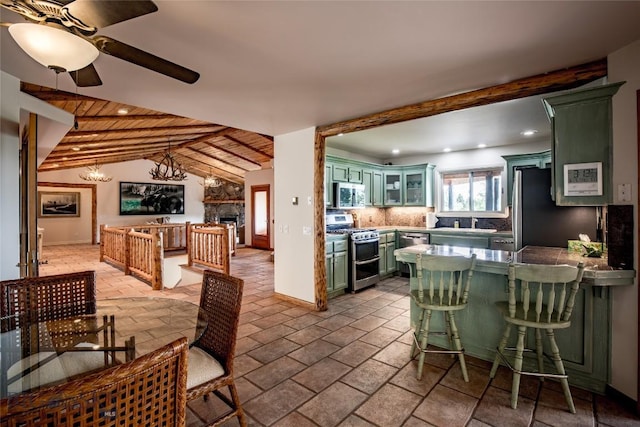 952 N Meadow Creek Rd, Mcallister, MT 59740 - kitchen featuring appliances with stainless steel finishes, green cabinets, recessed lighting, backsplash, and a fireplace