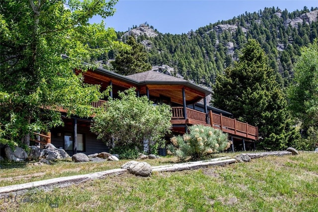 952 N Meadow Creek Rd, Mcallister, MT 59740 - back of house featuring a forest view and a deck with mountain view
