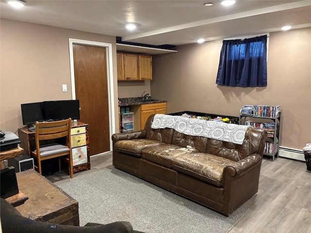 living area with recessed lighting, a baseboard radiator, light wood-type flooring, and bar