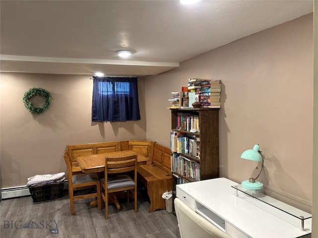 dining space featuring light wood-type flooring and a baseboard heating unit